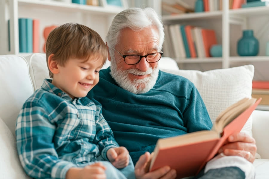Un grand-père et son petit-fils lisant un livre ensemble sur un canapé